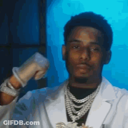 A Man In A Lab Coat Is Wearing Gloves And A Necklace GIF