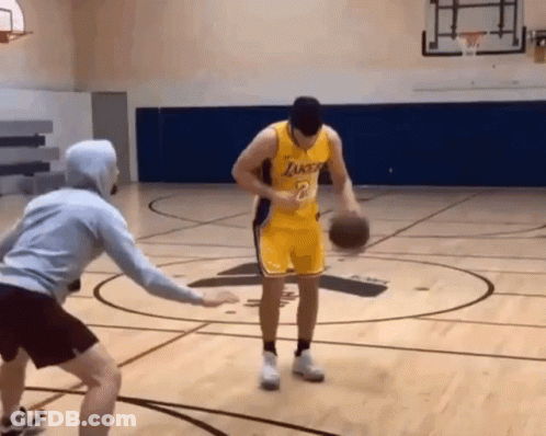 A Man In A Lakers Jersey Dribbles A Basketball On A Court GIF
