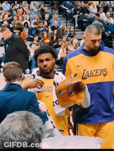 A Man In A Lakers Jersey Holds A Basketball In His Hand GIF
