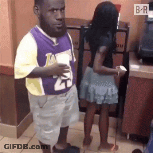 A Man In A Lakers Jersey Is Standing Next To A Woman GIF