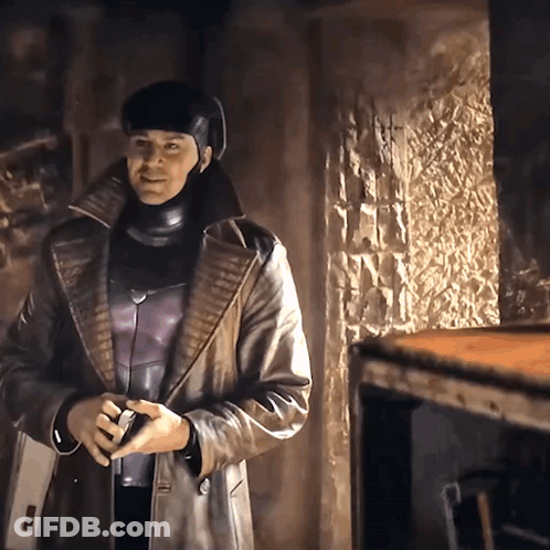 A Man In A Leather Coat And Helmet Is Standing In A Room GIF