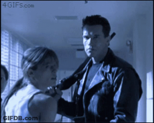 A Man In A Leather Jacket Holds A Gun To A Woman 'S Neck And Says 4Gifs.com GIF