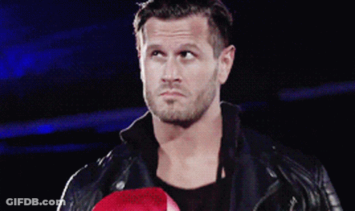 A Man In A Leather Jacket Holds A Red Boxing Glove GIF