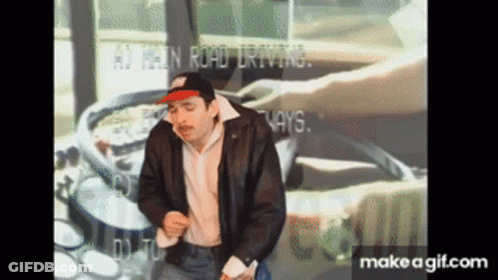 A Man In A Leather Jacket Is Dancing In Front Of A Screen That Says ' At Least Road Driving ' On It GIF