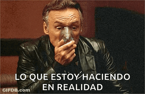 A Man In A Leather Jacket Is Drinking From A Glass With The Words " Lo Que Estoy Haciendo En Realidad " Below Him GIF