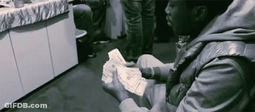 A Man In A Leather Jacket Is Holding A Bunch Of Money In His Hands GIF