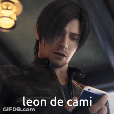 A Man In A Leather Jacket Is Holding A Cell Phone With The Words Leon De Cami Above Him GIF
