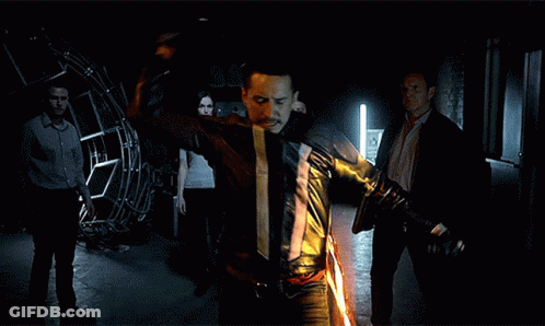 A Man In A Leather Jacket Is Holding A Flaming Sword GIF