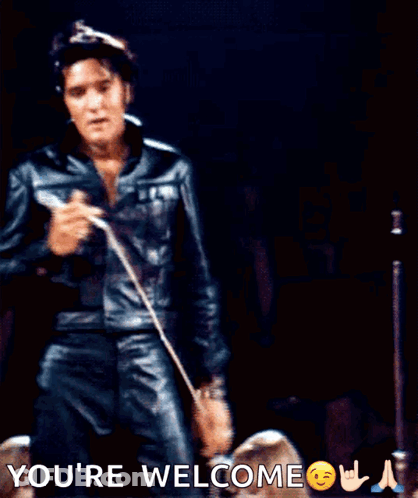 A Man In A Leather Jacket Is Holding A Microphone And The Words You 'Re Welcome Are Above Him GIF