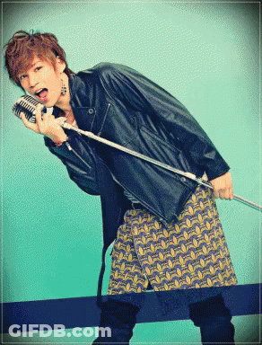 A Man In A Leather Jacket Is Holding A Microphone GIF