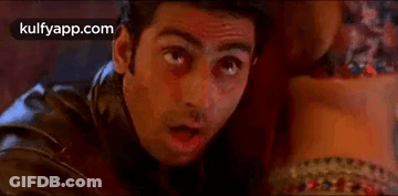 A Man In A Leather Jacket Is Looking At A Woman 'S Waist . GIF