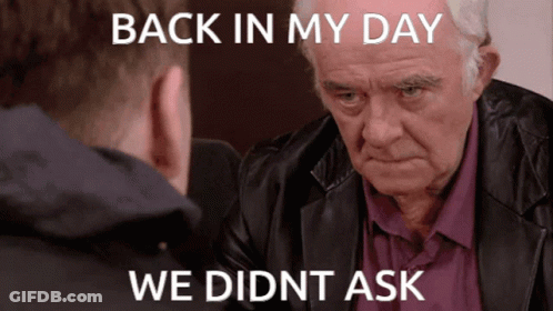 A Man In A Leather Jacket Is Looking At Another Man With The Caption Back In My Day We Didn T Ask GIF