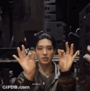A Man In A Leather Jacket Is Making A Face With His Hands In The Air GIF