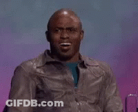 A Man In A Leather Jacket Is Making A Funny Face While Sitting In Front Of A Purple Background . GIF