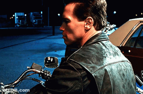 A Man In A Leather Jacket Is Riding A Motorcycle GIF