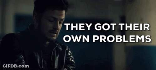 Man In Leather Jacket Sitting In Front Of Sign Saying They Got Their Own Problems GIF