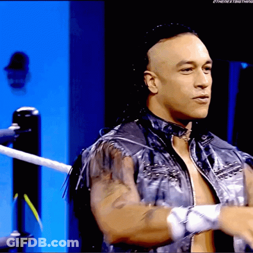 A Man In A Leather Jacket Is Standing In A Wrestling Ring GIF