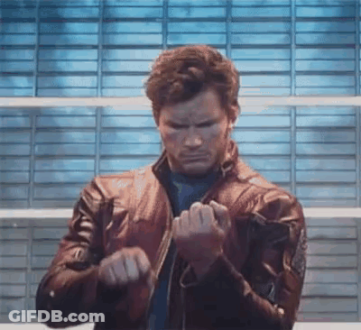 A Man In A Leather Jacket Is Standing In Front Of A Brick Wall And Making A Funny Face . GIF