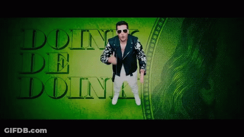 A Man In A Leather Jacket Is Standing In Front Of A Green Background That Says Doin ' De Doin ' GIF