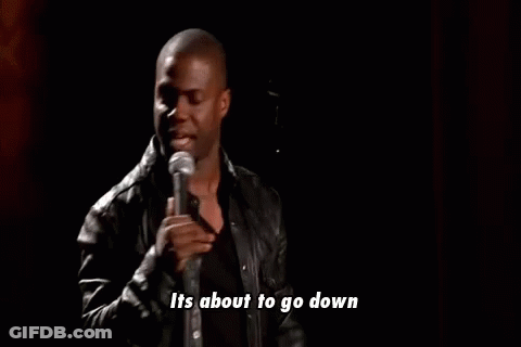 A Man In A Leather Jacket Is Standing In Front Of A Microphone And Talking Into It . GIF