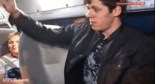 A Man In A Leather Jacket Is Standing In Front Of A Screen That Says " Rostov " On It GIF