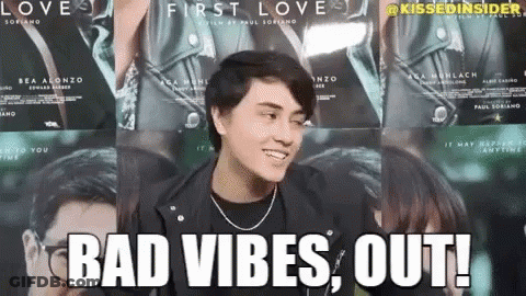 A Man In A Leather Jacket Is Standing In Front Of A Wall Of Posters For The Movie First Love . GIF