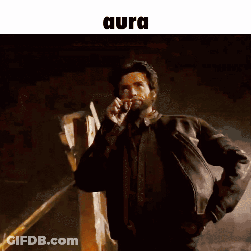A Man In A Leather Jacket Is Talking On A Cell Phone And The Word Aura Is Above Him GIF