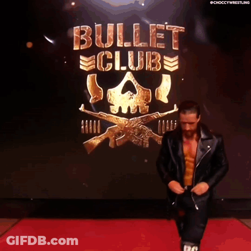 A Man In A Leather Jacket Is Walking Down A Red Carpet In Front Of A Bullet Club Logo GIF