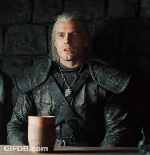 A Man In A Leather Jacket Sits At A Table With A Cup On It GIF