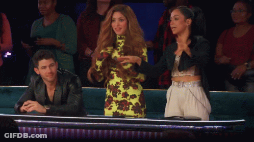 A Man In A Leather Jacket Sits Next To A Woman In A Green Dress GIF