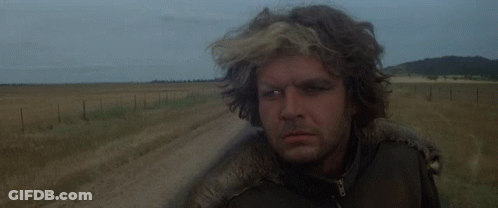 A Man In A Leather Jacket Stands In A Field GIF