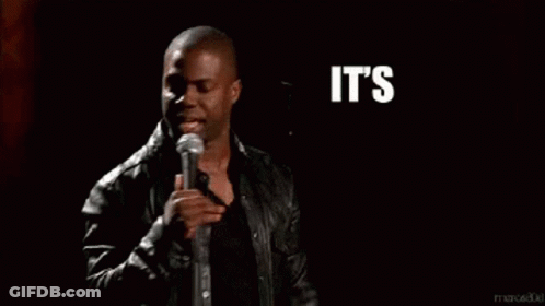 A Man In A Leather Jacket Stands In Front Of A Microphone With The Words It 'S About To Go Down Behind Him GIF