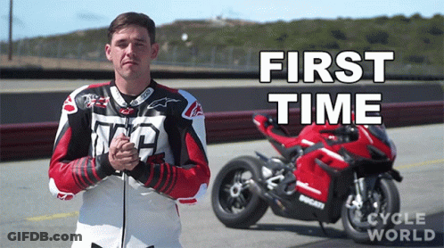 A Man In A Leather Jacket Stands In Front Of A Red Motorcycle That Says First Time GIF