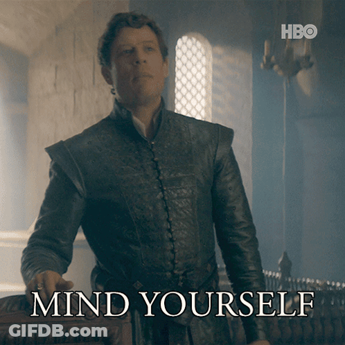 A Man In A Leather Jacket Stands In Front Of A Sign That Says " Mind Yourself " GIF