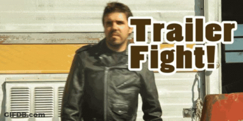 A Man In A Leather Jacket Stands In Front Of A Trailer That Says Trailer Fight On It GIF