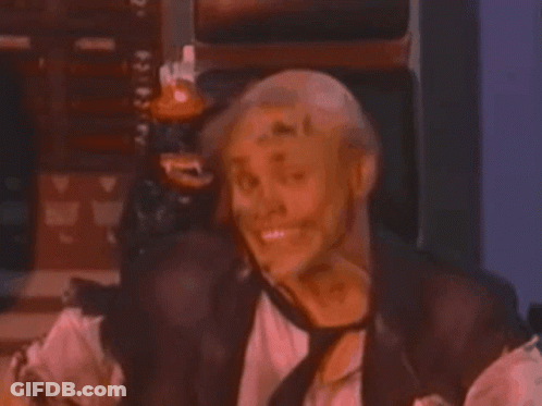 A Man In A Leather Vest And Tie Is Laughing GIF