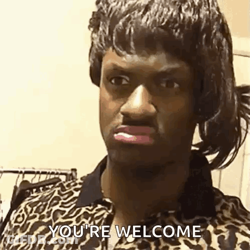 A Man In A Leopard Print Shirt Is Saying `` You 'Re Welcome '' While Wearing A Wig . GIF