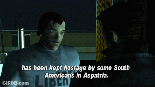 A Man In A Liberty Shirt Talks To Another Man In A Dark Room GIF