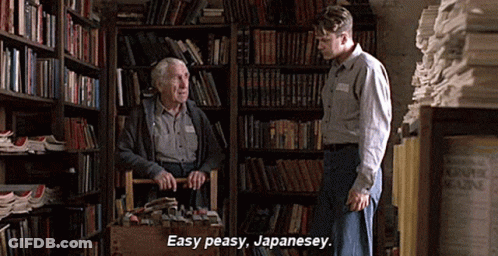 A Man In A Library Talking To An Older Man Who Is Carrying A Basket Full Of Books . GIF