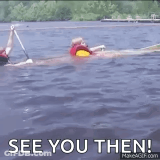 A Man In A Life Jacket Is Swimming In A Lake . GIF