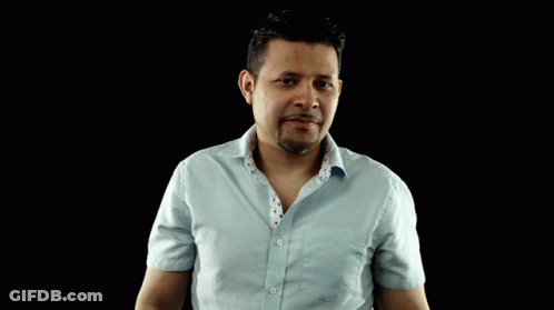 A Man In A Light Blue Shirt Is Making A Gesture With His Hands GIF