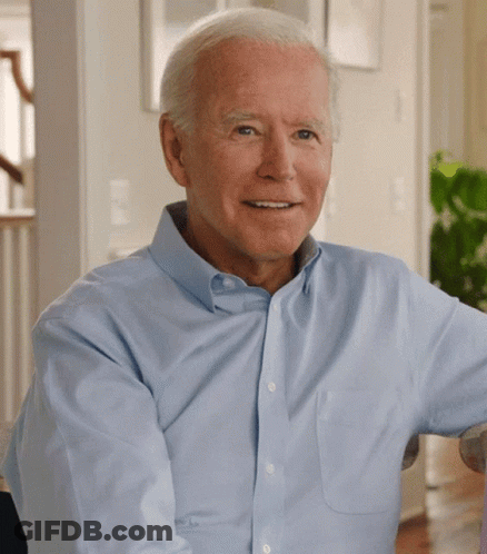 A Man In A Light Blue Shirt Is Smiling For The Camera GIF