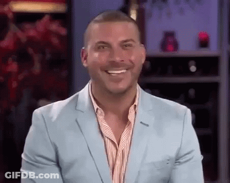 A Man In A Light Blue Suit Is Smiling . GIF