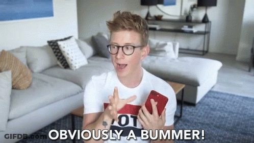 A Man In A Living Room Holding A Cell Phone And Says Obviously A Bummer GIF