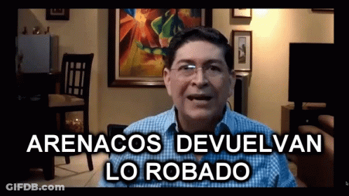 A Man In A Living Room With The Words Arenacos Devuelvan Lo Robado GIF
