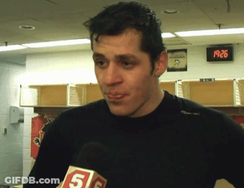 A Man In A Locker Room With A Penguins Sign On The Wall GIF
