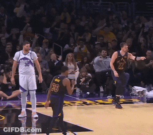 A Man In A Los Angeles Lakers Jersey Stands In Front Of A Crowd GIF