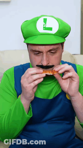 A Man In A Luigi Costume Eating A Piece Of Pizza GIF