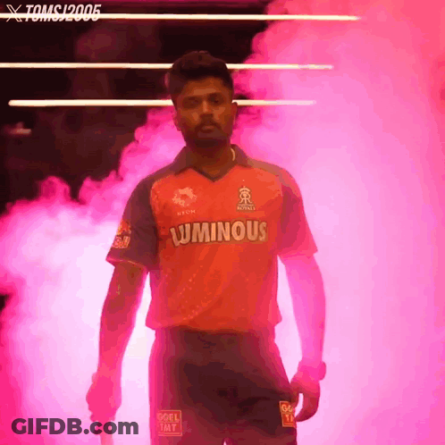 A Man In A Luminous Shirt Stands In A Pink Smokey Room GIF