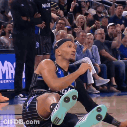 A Man In A Magic Jersey Is Kneeling Down On The Court GIF